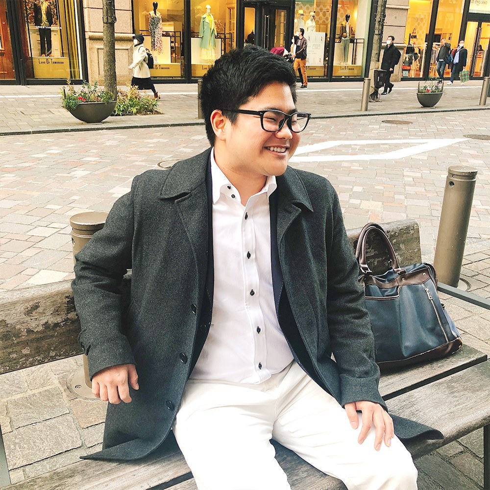 ベンチに座っている岩田啓太郎の自然体の写真